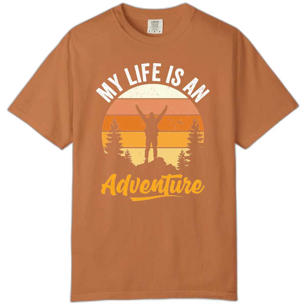 Retro sunset illustration with silhouette of person celebrating arms raised, evergreen trees and mountains, text 'My Life Is An Adventure' in Yam