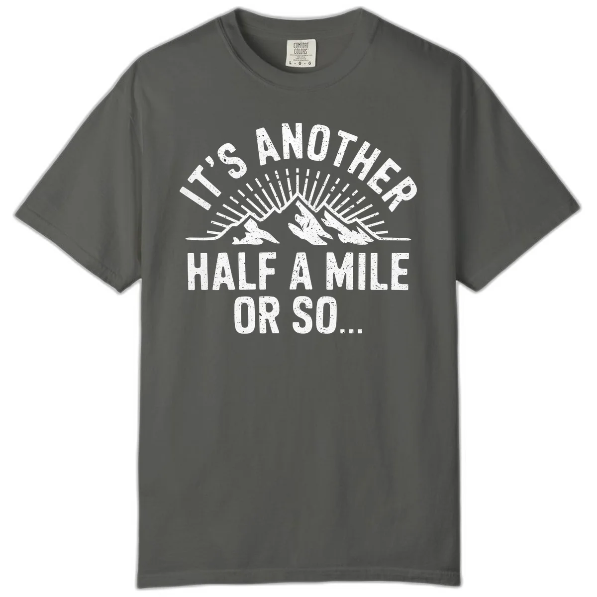 Retro distressed design with mountain peaks and sun rays, text reads 'It's Another Half A Mile Or So' - humorous hiking and camping artwork in Pepper