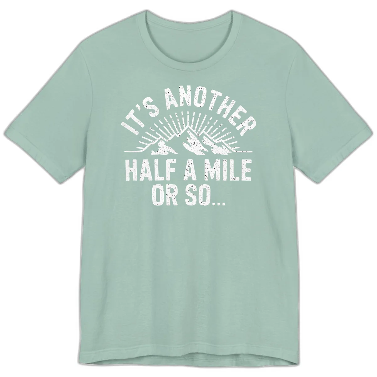 Retro distressed design with mountain peaks and sun rays, text reads 'It's Another Half A Mile Or So' - humorous hiking and camping artwork in Dusty Blue