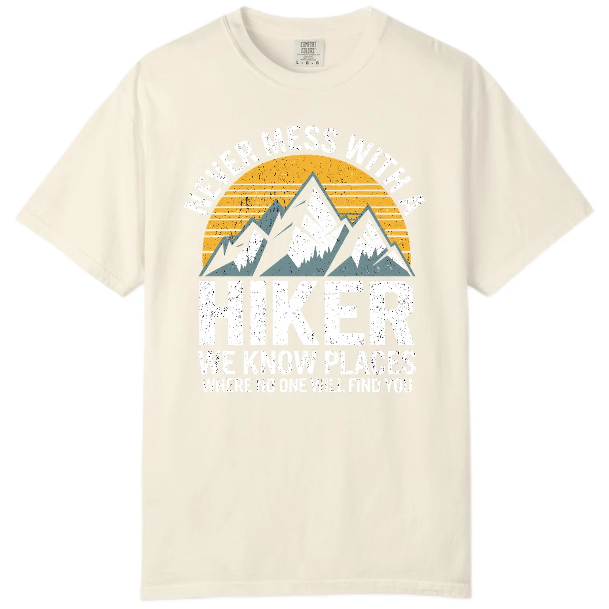 Vintage-style design with snow-capped mountains and forest silhouette against striped sunset, text reads 'Never Mess With A Hiker We Know Places Where No One Will Find You' in Ivory