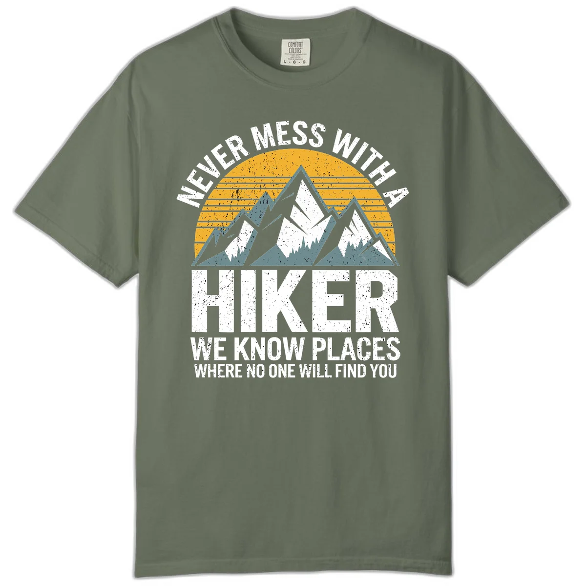 Vintage-style design with snow-capped mountains and forest silhouette against striped sunset, text reads 'Never Mess With A Hiker We Know Places Where No One Will Find You' in Moss