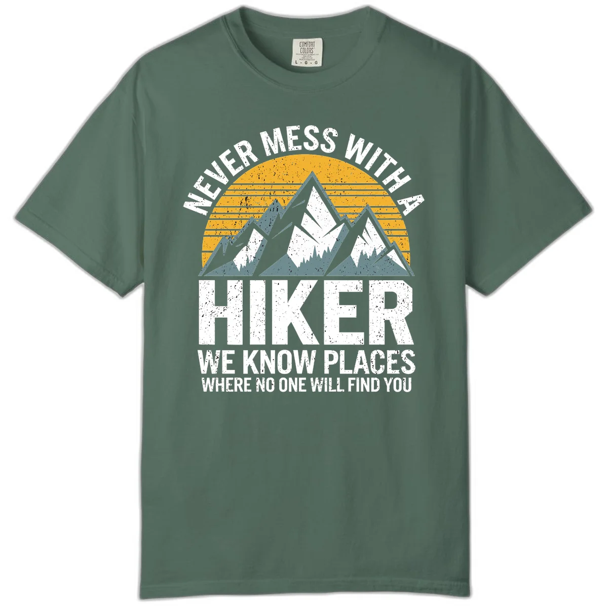 Vintage-style design with snow-capped mountains and forest silhouette against striped sunset, text reads 'Never Mess With A Hiker We Know Places Where No One Will Find You' in Blue Spruce