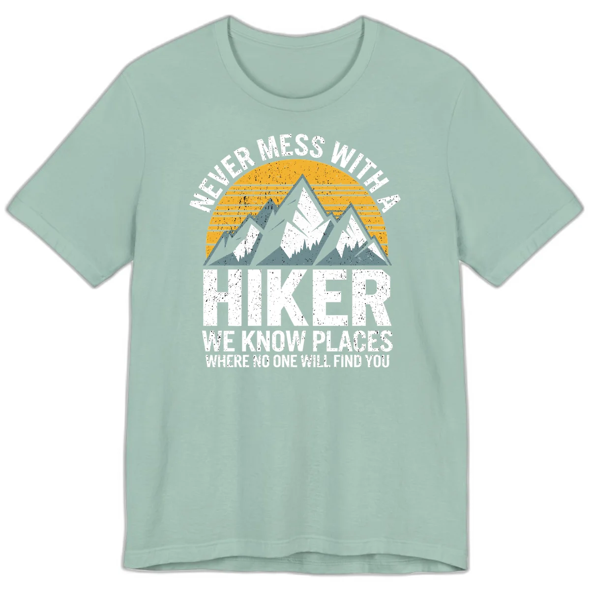 Vintage-style design with snow-capped mountains and forest silhouette against striped sunset, text reads 'Never Mess With A Hiker We Know Places Where No One Will Find You' in Dusty Blue