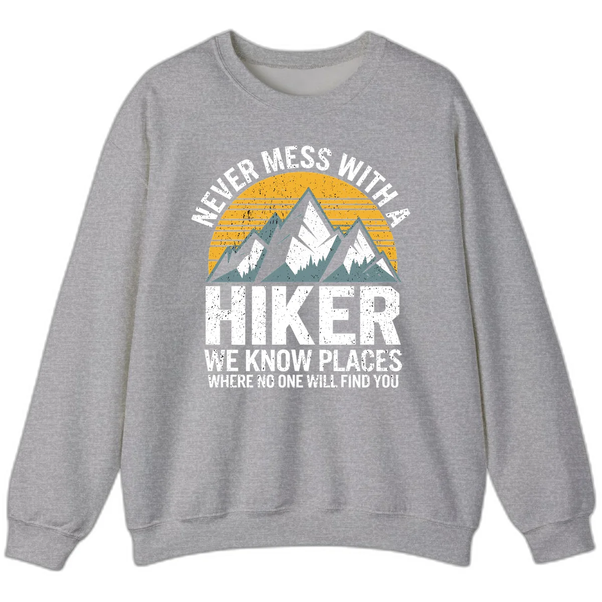 Vintage-style design with snow-capped mountains and forest silhouette against striped sunset, text reads 'Never Mess With A Hiker We Know Places Where No One Will Find You' in Sport Grey