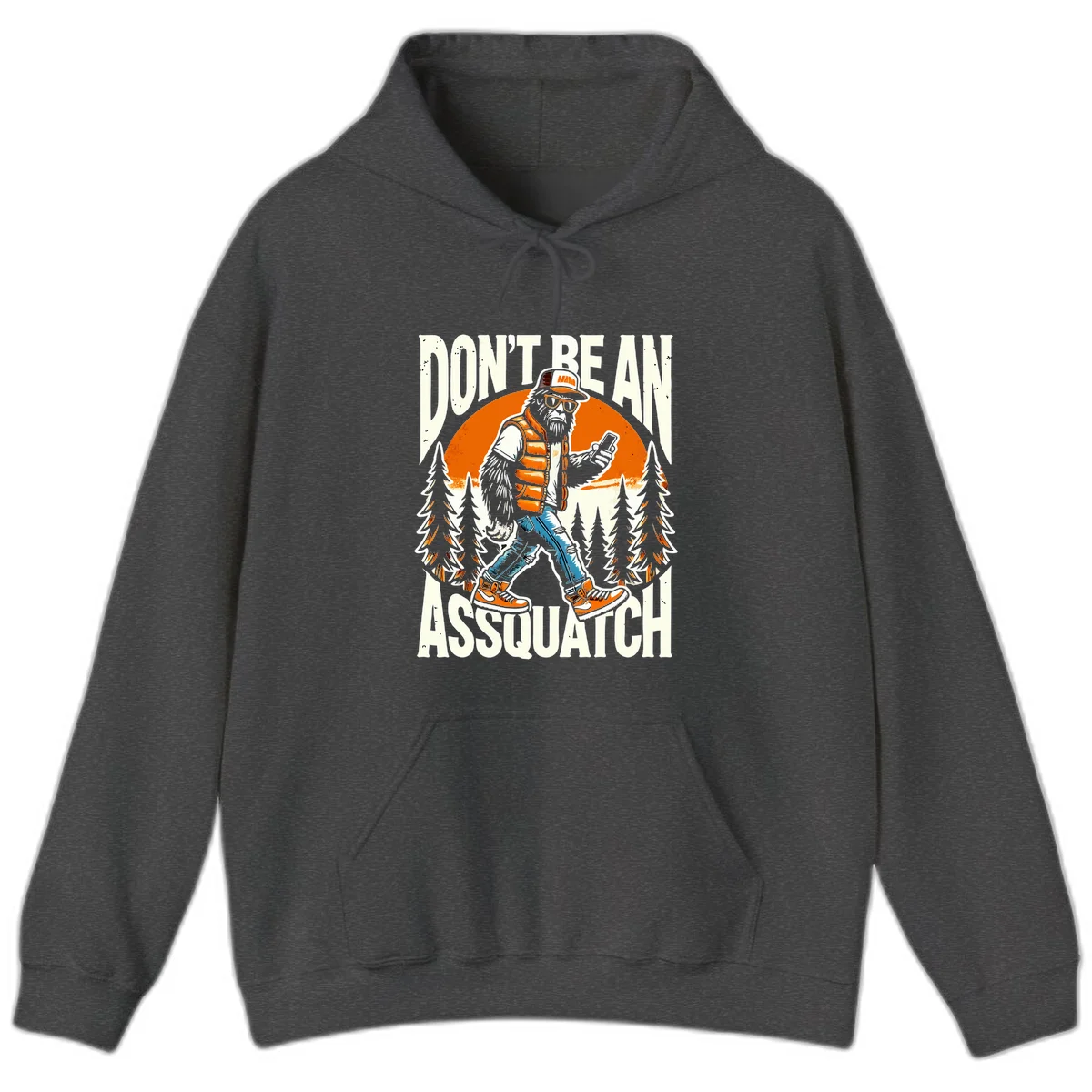 Cartoon sasquatch in hiking gear with backpack and smartphone, 'Don't Be An Assquatch' text, forest and orange sun background. in Dark Heather