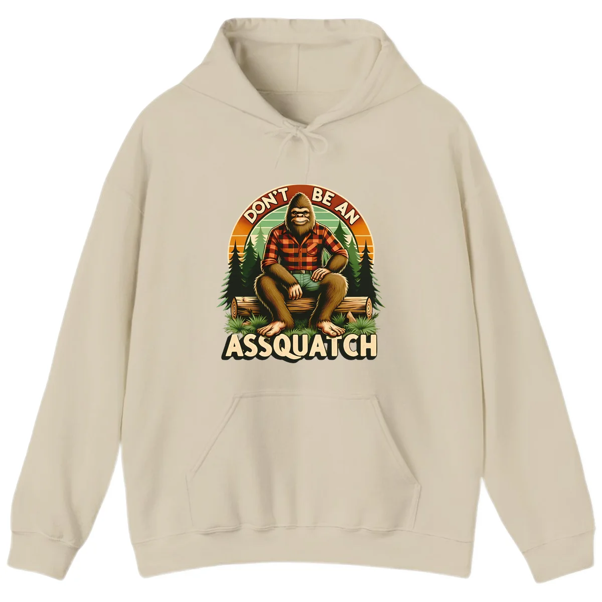 Vintage badge design with friendly Bigfoot in plaid shirt sitting on a log with forest trees, text reads 'Don't Be An Assquatch' in Sand