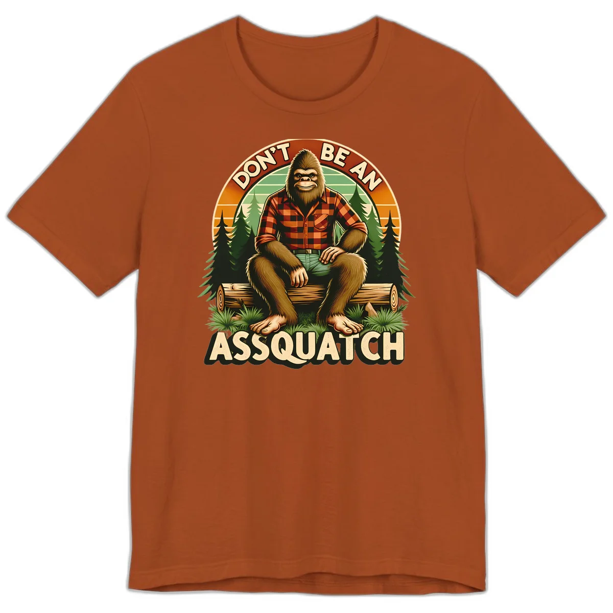Vintage badge design with friendly Bigfoot in plaid shirt sitting on a log with forest trees, text reads 'Don't Be An Assquatch' in Autumn
