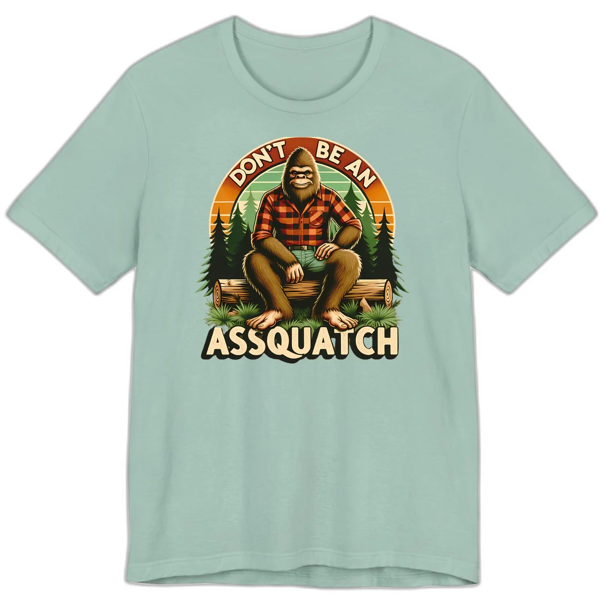 Vintage badge design with friendly Bigfoot in plaid shirt sitting on a log with forest trees, text reads 'Don't Be An Assquatch' in Dusty Blue