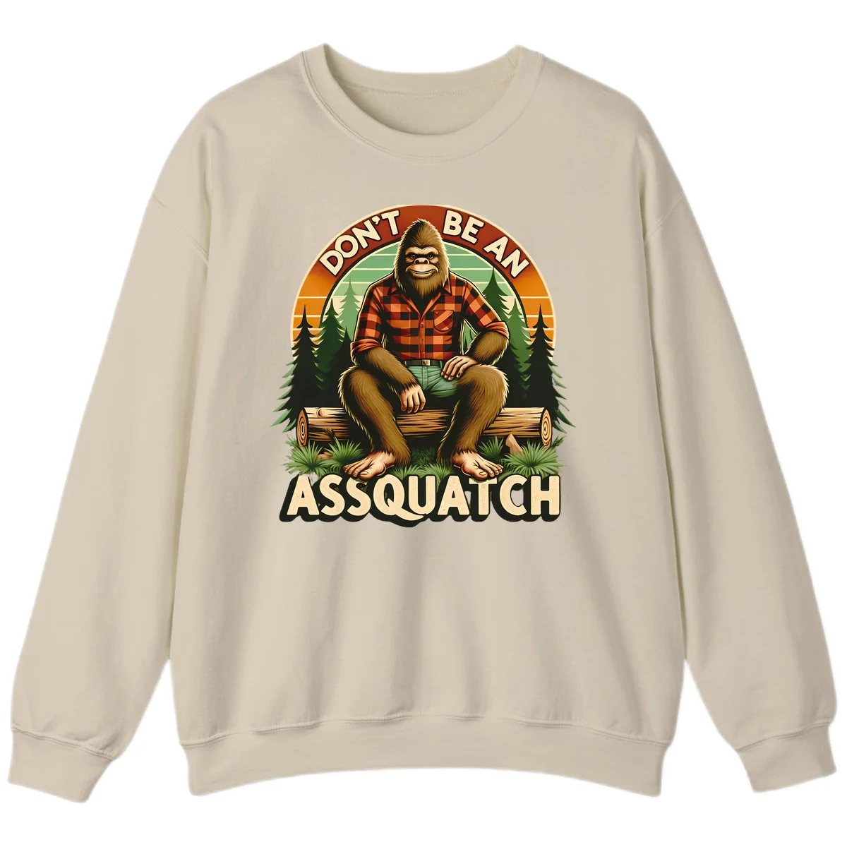 Vintage badge design with friendly Bigfoot in plaid shirt sitting on a log with forest trees, text reads 'Don't Be An Assquatch' in Sand