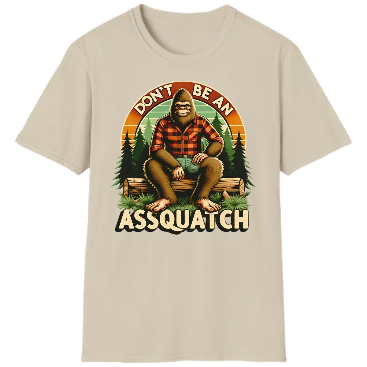 Vintage badge design with friendly Bigfoot in plaid shirt sitting on a log with forest trees, text reads 'Don't Be An Assquatch' in Sand